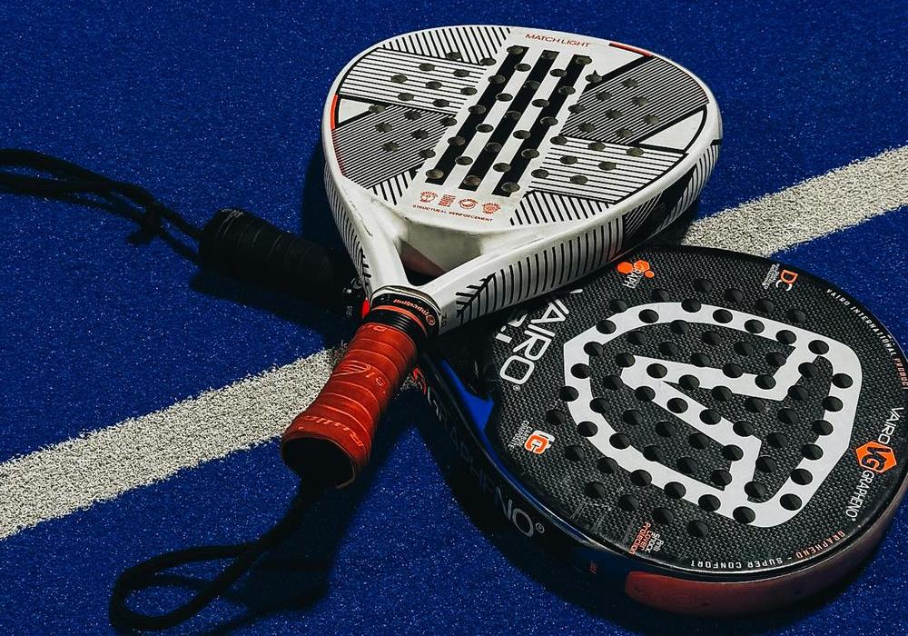 Padel rackets and ball on blue court